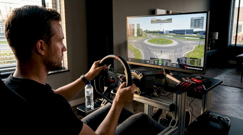 Een simracer stelt thuis zijn force feedback stuur nauwkeurig af voor de perfecte rijervaring.