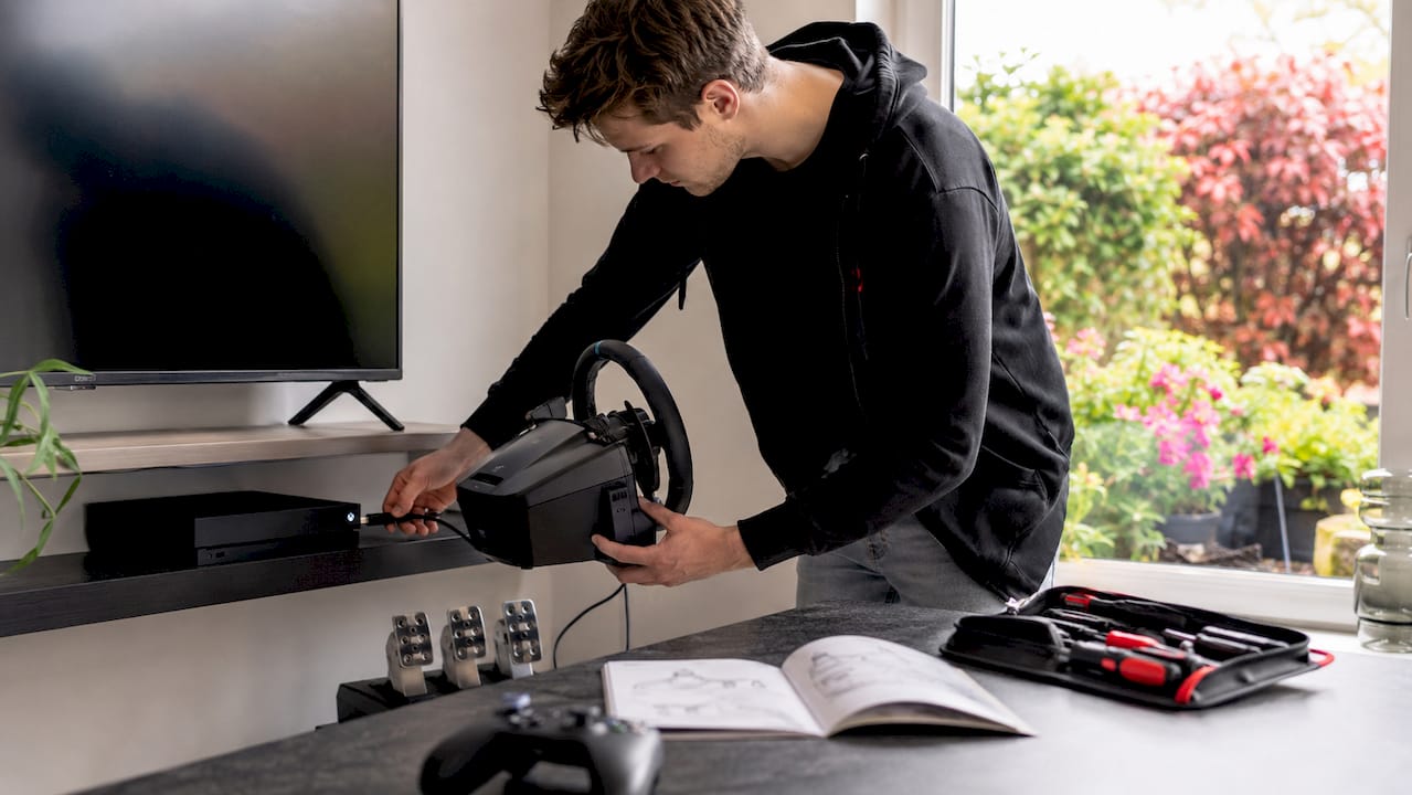 Man sluit racestuur aan op zijn Xbox-console