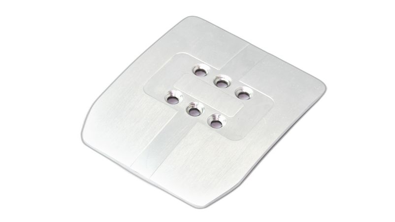 Een vierkante, zilver metalen Fanatec T-LCM rempedaalkop met schuine hoeken en zes centrale gaten in een rechthoekige layout.